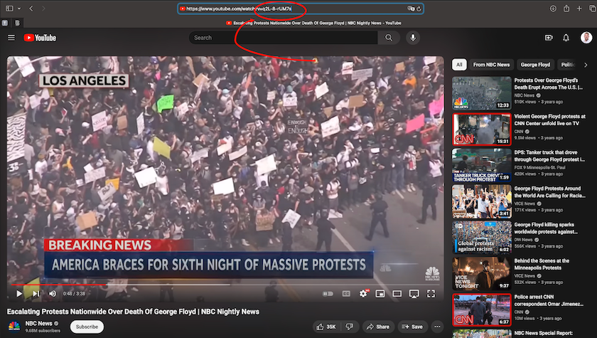 Screenshot of a YouTube video from this lesson's dataset showing the location of the static (unchanging) video ID in the video's URL, with the final sequence of letters, numbers, and special symbols circled in red. A still image from the video shows a large protest, and includes the caption, 'Breaking News - America Braces for Sixth Night of Massive Protests'.